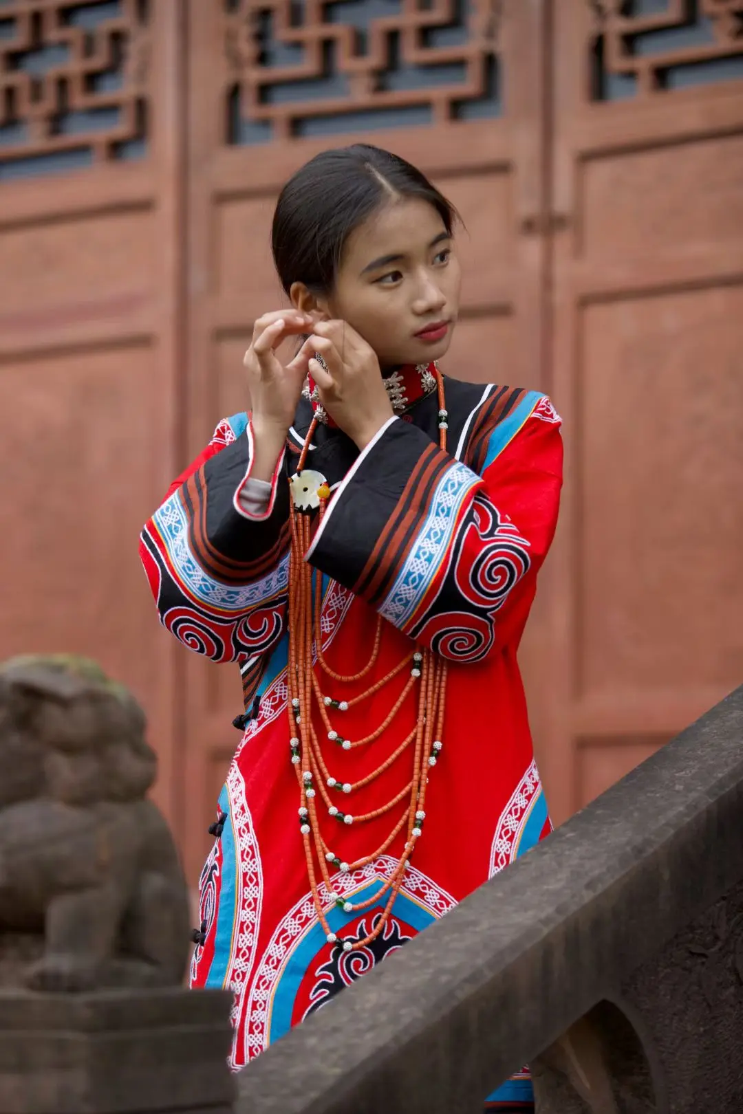 A young Yi woman in traditional dress at a temple